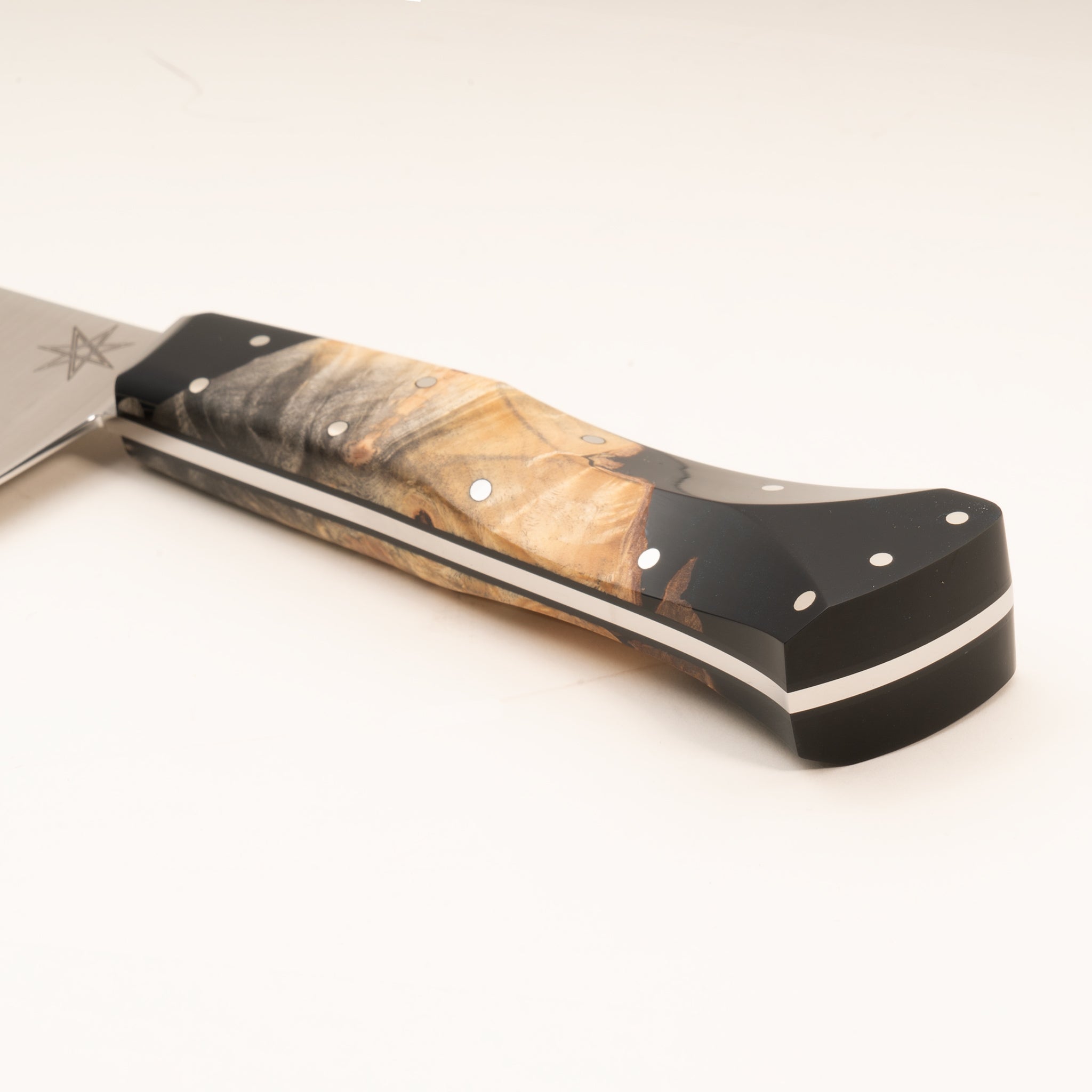 Close-up of a kitchen chef knife handle made from wood and black resin, on a white background.