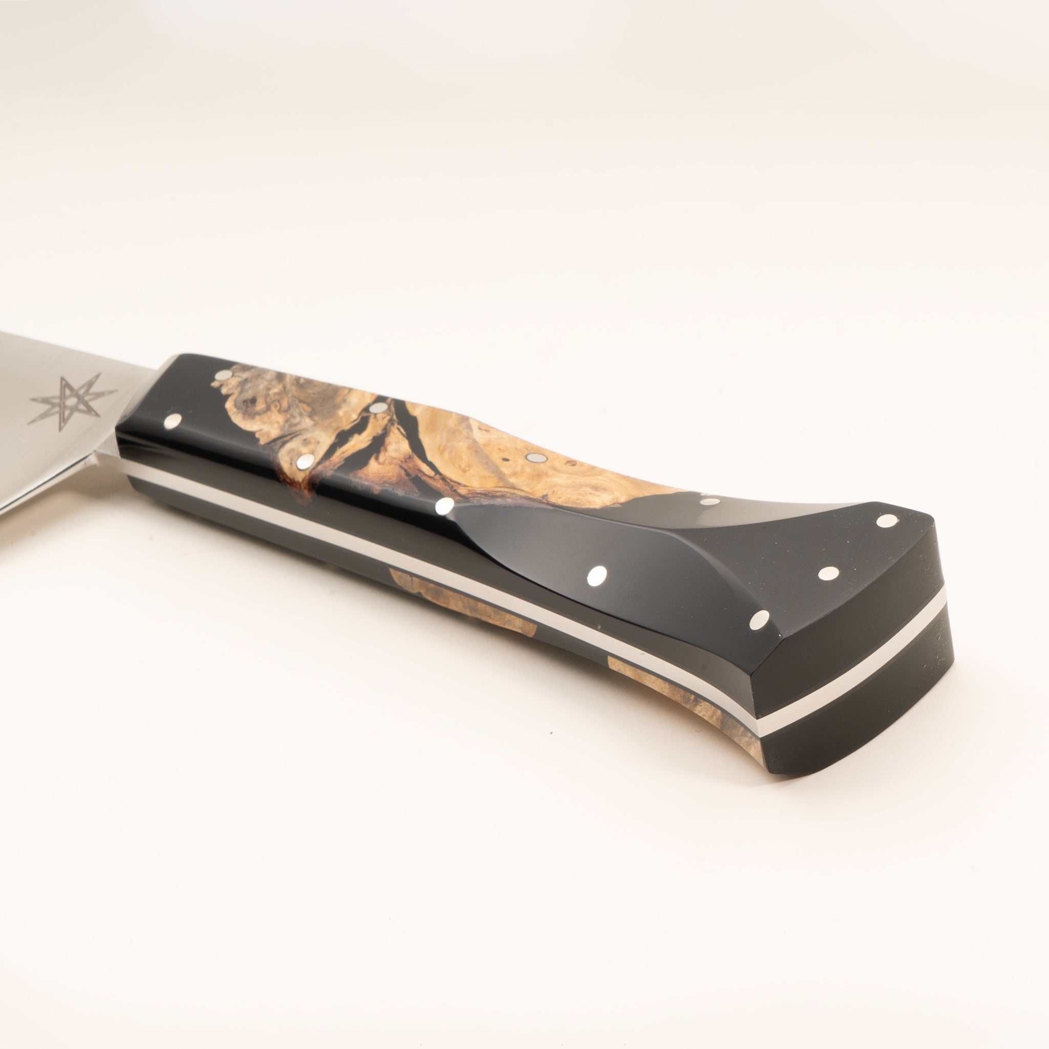 Detail photo of a scimitar butcher knife handle with wood and resin handle on a white background.