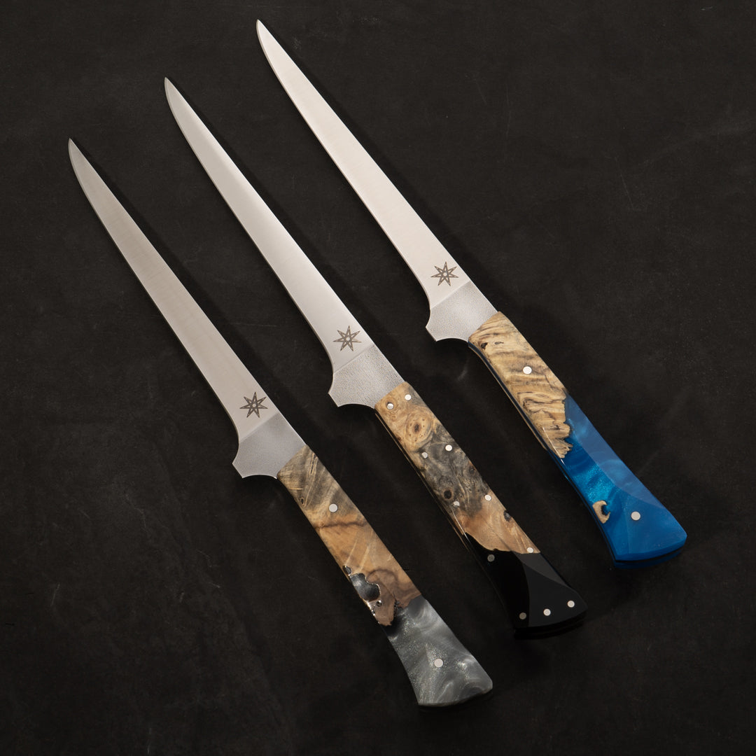 Three kitchen straight boning knives with different color wood and resin handles.
