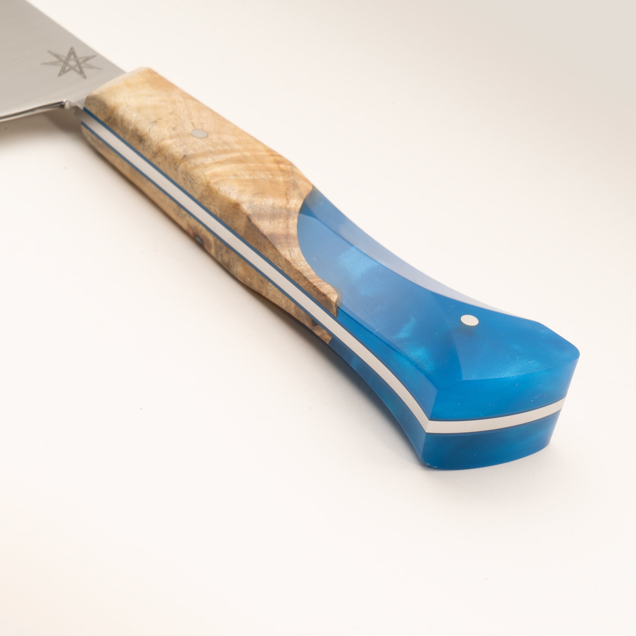Detail photo of knife handle of Tahoe Bliss stainless steel chef knife with buckeye burl wood and blue resin handle by Town Cutler.