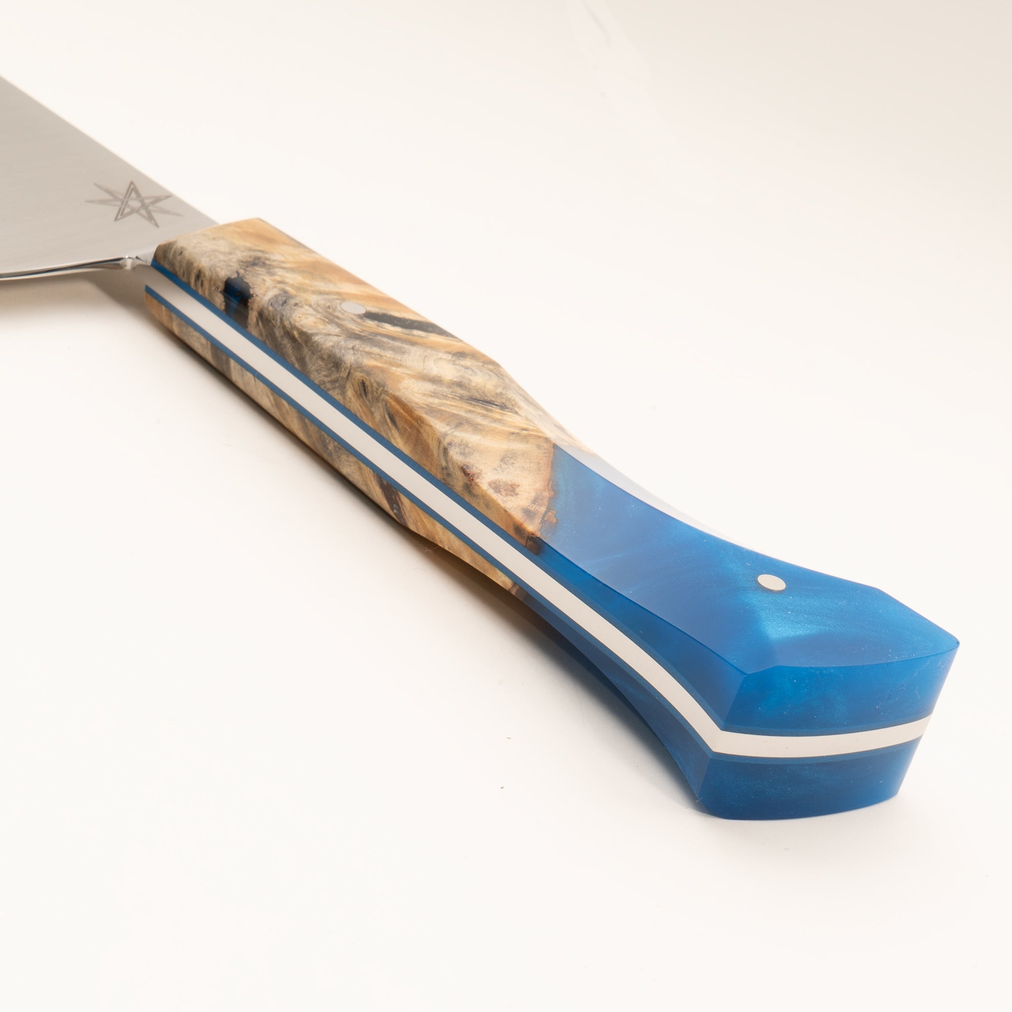 Detail photo of knife handle of Tahoe Bliss stainless steel chef knife with buckeye burl wood and blue resin handle by Town Cutler.