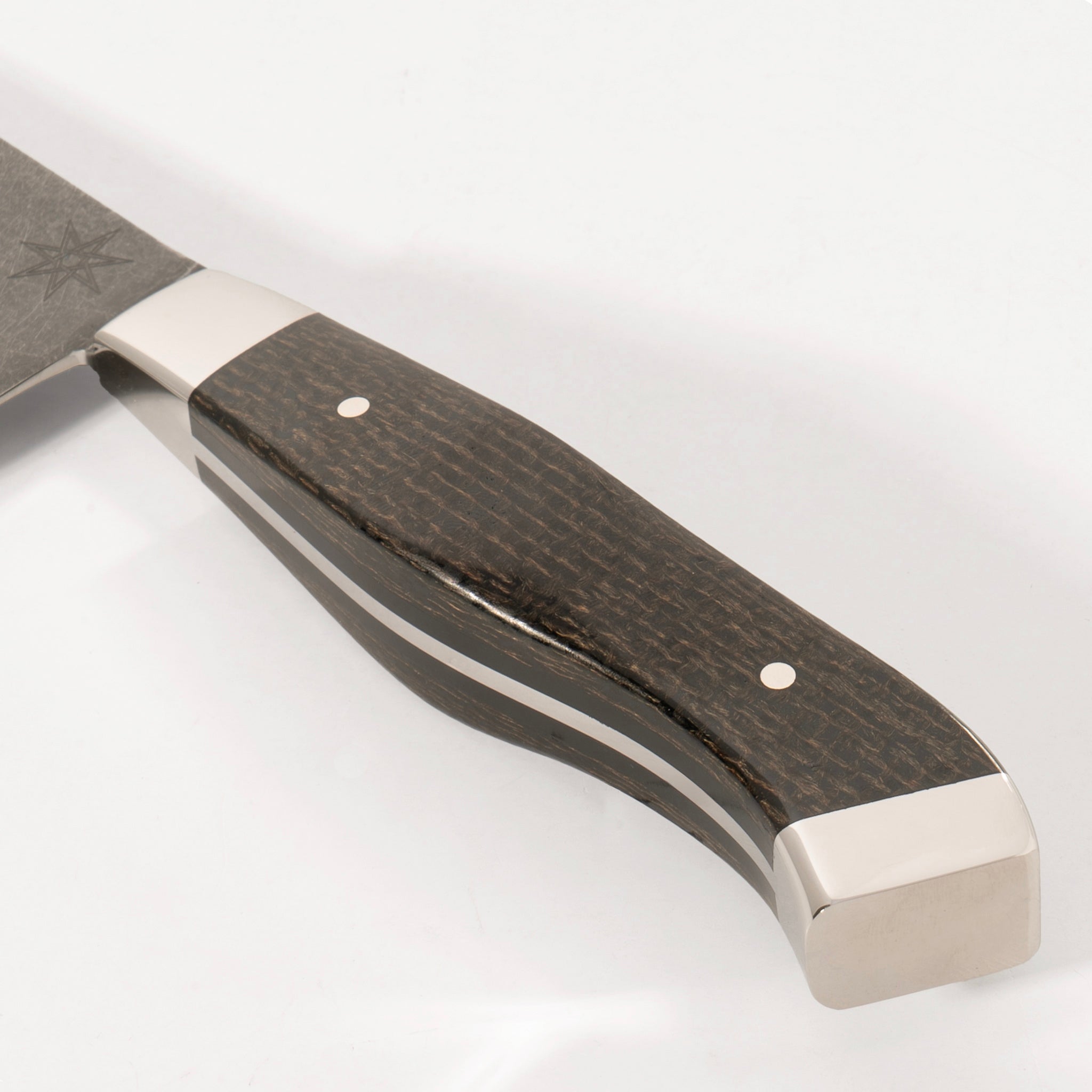 Detail photo of handle on 7" Carbon Steel Chef Knife with Stonewash Finish Blade, Black Burlap Micarta Handle, Stainless Steel Bolster and Pommel by Town Cutler